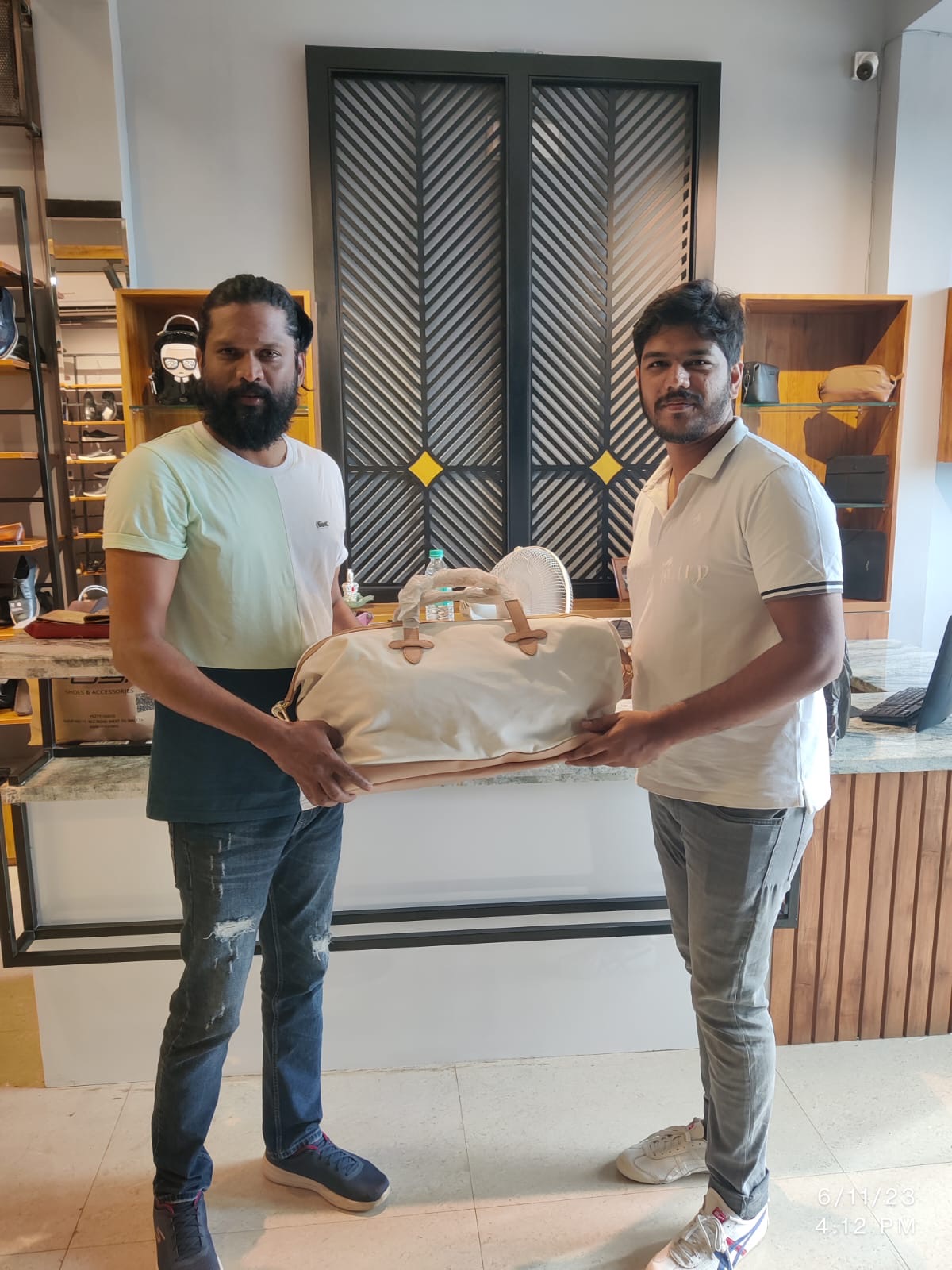 A customer receiving a travel bag at POSH